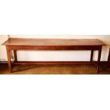 A late 19th Century grained pine farmhouse kitchen table, raised on block tapered supports united