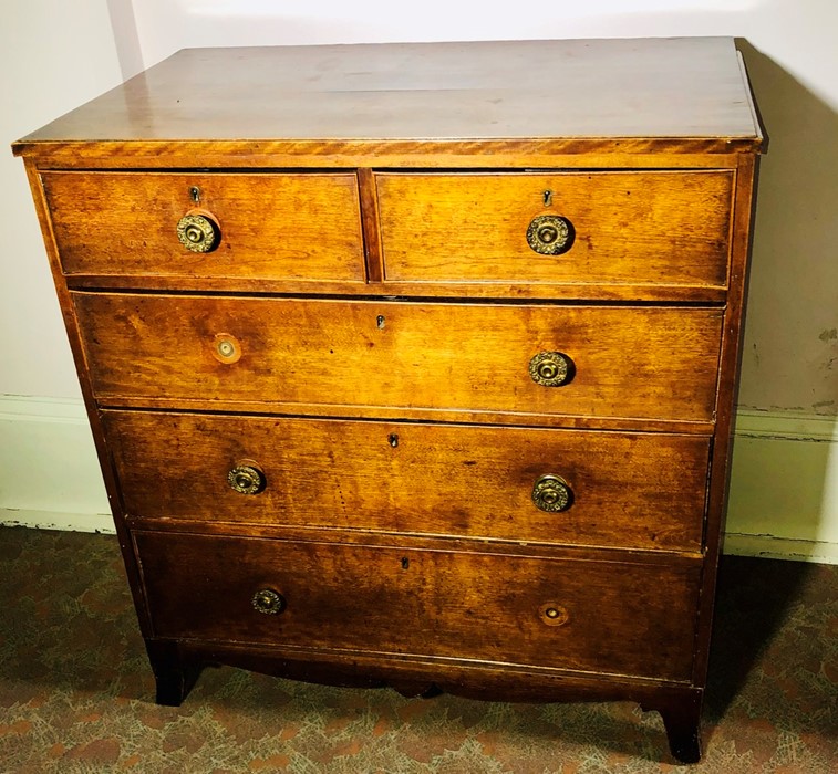 An early Victorian oak chest of drawers, circa 1850, moulded edge top above two short and three long