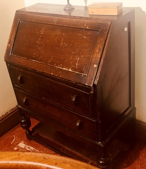 A mid 20th century oak fall front bureau, enclosing with fitted pigeon holes, above two drawers