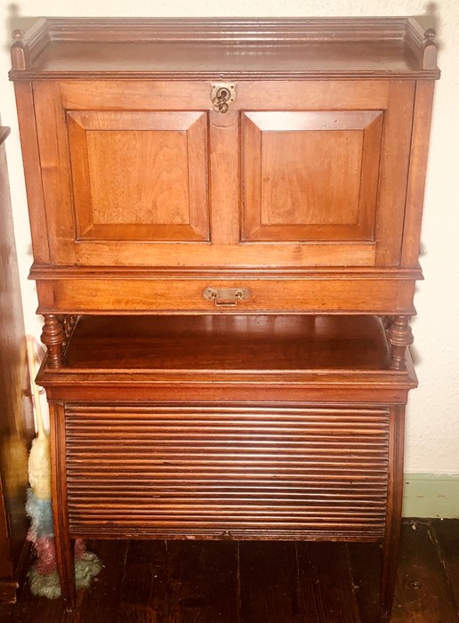 An early 20th century oak fall front bureau on tambour cupboard, three quarter gallery top above a