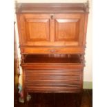 An early 20th century oak fall front bureau on tambour cupboard, three quarter gallery top above a