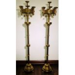 A pair of 19th Century Ecclesiastical brass seven branch tall candle stands, in the manner of