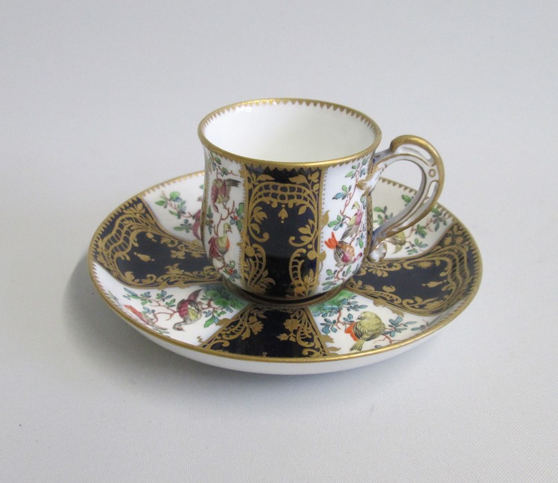 An English Porcelain Cup and Saucer Decorated with Exotic birds and cobalt blue panels with gilt