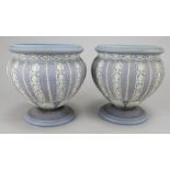 A pair of early nineteenth century Wedgwood jasper ware urns decorated with white sprigs, c. 1820.