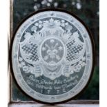 A late 18th Century German oval etched glass panel, scrollwork heraldic crest containing crossed
