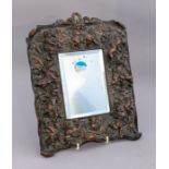 A late 19th Century cast copper wall looking glass