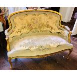 A Louis XV revival giltwood two seater sofa, centre top foliage carving on a spoon back with