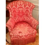 A late 19th Century wingback nursing armchair, mounted red tapestry fabric, scrolling arms on a