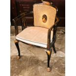 A 1920's chinoiserie lacquered cane back armchair, scrolling top above cane work back and seat,