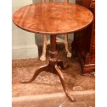 A George III mahogany tilt top table, circa 1820, circular top above a turned column, on a tripod