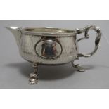An art and crafts silver milk jug with hammered de