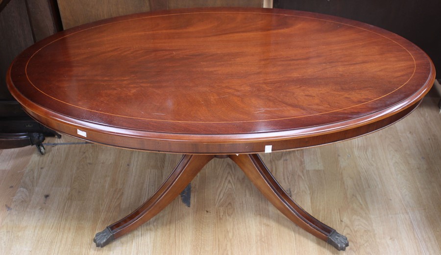 A contemporary mahogany effect oval pedestal coffee table, measuring 53cm high, 125cm wide, 71cm