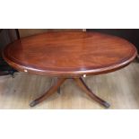 A contemporary mahogany effect oval pedestal coffee table, measuring 53cm high, 125cm wide, 71cm