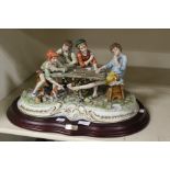 A large Capodimonte figure on stand of four Italian boys playing card The Beggars
