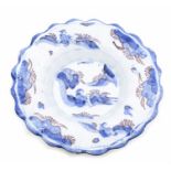 A German early 18th Century faience blue and white lobed dish, the centre and border decorated