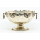 A George VI silver large shaped circular bowl, wavy rim applied with scrolling leaf motifs, plain