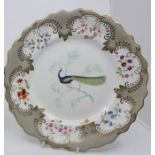 A 19th century shaped porcelain plate, the centre painted with a peacock on branch, scrolling border