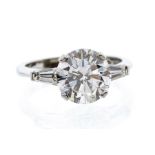 A diamond and platinum ring, comprising a central brilliant cut diamond of approx 3.8 carats,