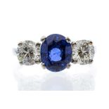 A sapphire and diamond three stone ring, comprising an oval sapphire claw set to the centre.