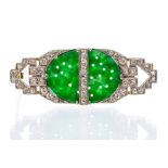 An Art Deco jade and diamond brooch, the rectangular brooch set to the centre with an oval jade with