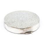 A silver mirror compact complete with powder puff, circular design with textured bark decoration,