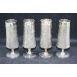 A set of four Modern silver champagne flutes, tapering cylindrical bodies with rusticated decoration