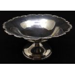 A George V silver circular bowl on stand / tazza, scroll rim above plain body, on trumpet foot, by