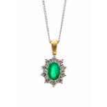 An emerald and diamond 18ct gold cluster pendant, comprising a central oval emerald weighing