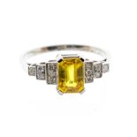 A yellow sapphire and diamond platinum dress ring, comprising a claw set rectangular cut sapphire,