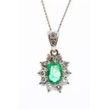 An emerald and diamond  18ct white gold cluster pendant, comprising a claw set oval mixed cut