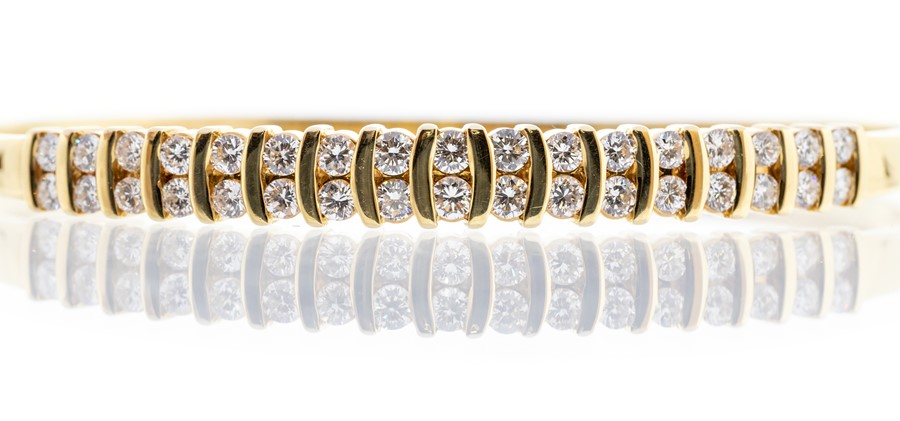 A diamond and 18ct gold double row bangle, comprising channel set brilliant cut diamonds, total