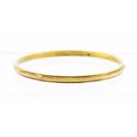 An 18ct gold bangle, ridged decoration, width approx 4.8mm, internal diameter approx 68mm,