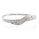 A diamond and 18ct white gold bangle, the top comprising an over lay sweep set with a double row