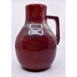 Ruskin Pottery: A Ruskin Pottery single handled jug with sang de boeuf and green high fired glaze,