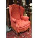 A George I style walnut wing chair, circa 1920, red upholstery throughout, raised on turned legs