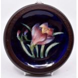 Moorcroft: A Walter Moorcroft 'Crocus' pattern coaster on a dark blue ground. Diameter approx 11.