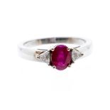 A ruby and diamond 18ct white gold ring, the central oval cut claw set ruby weighing approx 1 carat,