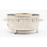 An Arts & Crafts circular two handled bowl, mottled body applied Latin banners with Portcullis and