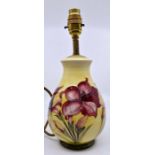 Moorcroft: A Walter Moorcroft 'African Lily' lamp base on a yellow ground. Height 20cm approx,