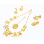 A high carat gold jewellery suite, comprising a necklace, with oval pierced domes and fringed tassel