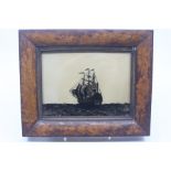 A 19th Century silhouette of a ship at sea in walnut frame