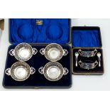 A pair of Victorian oval silver salts, scroll handles with openwork bodies on ball feet, with