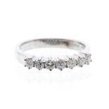 A diamond and 18ct white gold ring, comprising a row of  seven claw set round brilliant cut