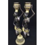 Two African bronzed and gilt figures of a seated women with baskets aloft and an Asian bell (3)