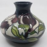 A Moorcroft squat vase, Magnolia pattern, blue ground. impressed marks to base, approx 12cm high