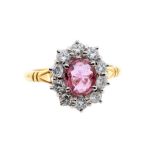 A ruby and diamond 18ct yellow gold cluster ring, comprising a central set oval ruby weighing approx