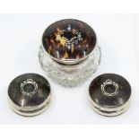 A George V cut glass dressing table bottle with silver mounted tortoishell cover inlaid with