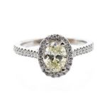 A fancy yellow diamond and 18ct white gold ring, comprising a claw set oval cut fancy yellow diamond