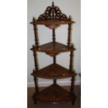 An Edwardian walnut four tier corner whatnot. 130 cms.