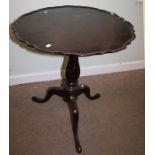 An early 19th century mahogany snap top tripod table, the circular pie-crust top on a baluster